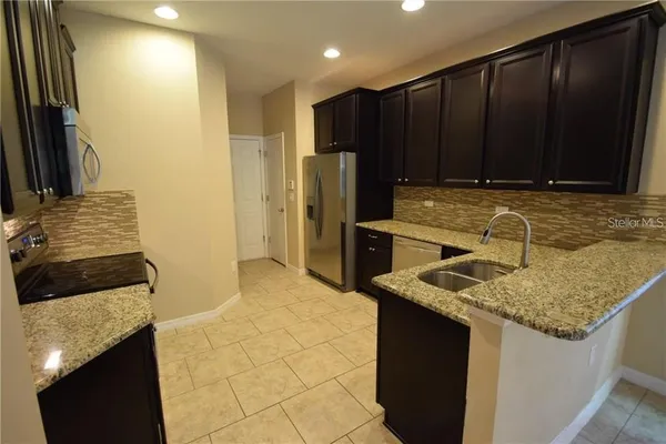 a kitchen with wooden cabinets and a granite counter top
