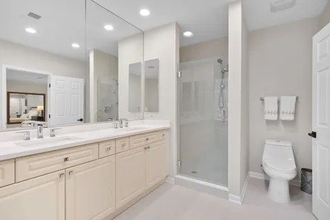 a bathroom with a double vanity sink toilet and shower
