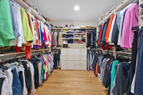 a view of walk in closet with clothes and shoes