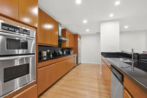 a kitchen with stainless steel appliances kitchen island granite countertop a stove a sink and a microwave