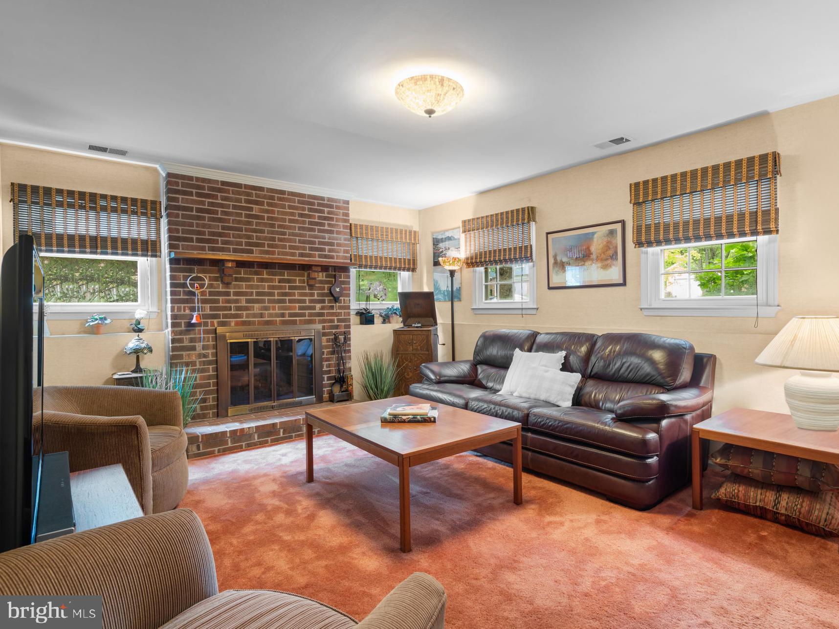 1709 Glastonberry Road Rockville, MD 20854 - Photo 12 of 27 a living room with furniture a fireplace and a large window