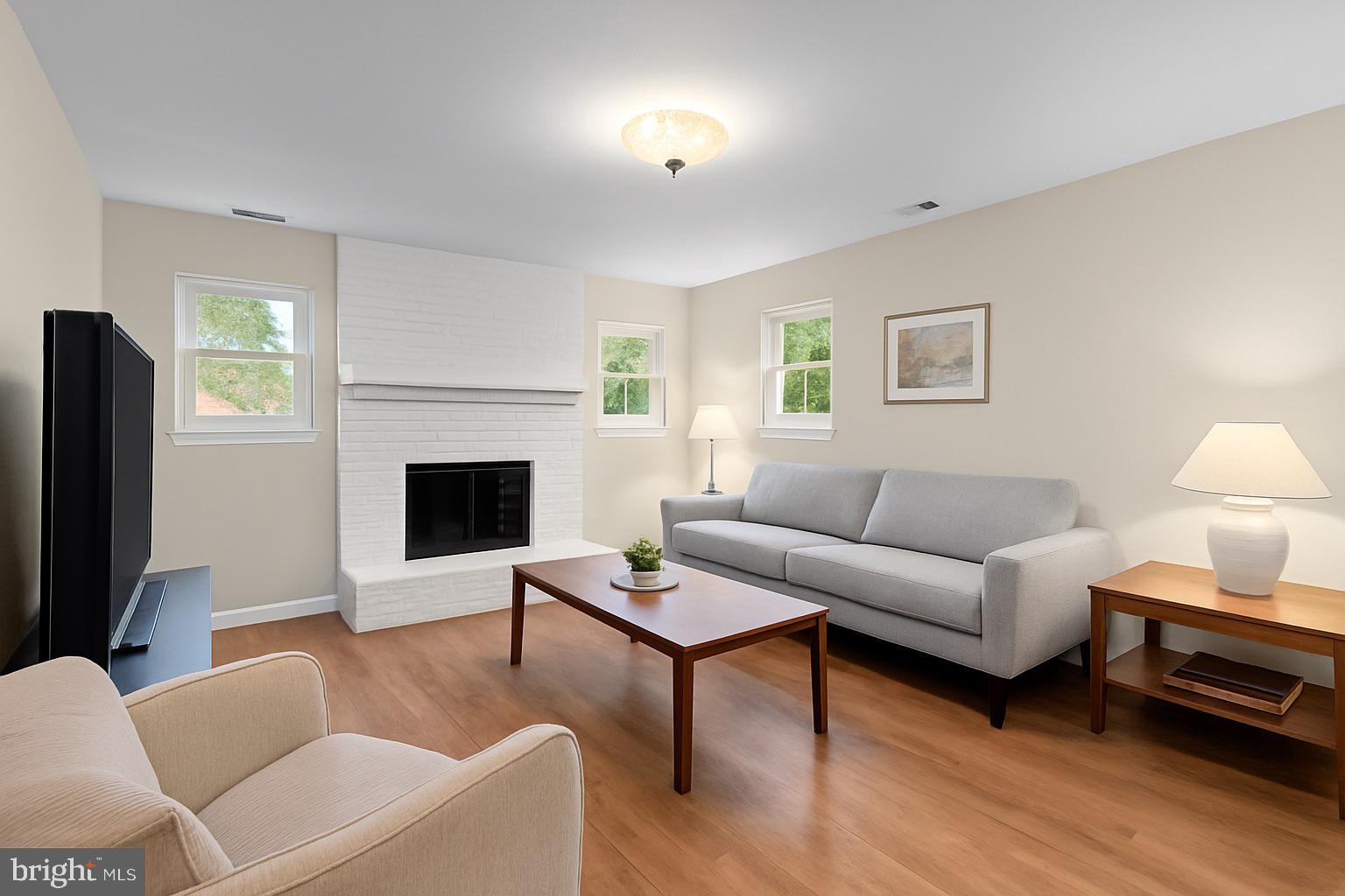1709 Glastonberry Road Rockville, MD 20854 - Photo 14 of 27 a living room with furniture a flat screen tv and a fireplace