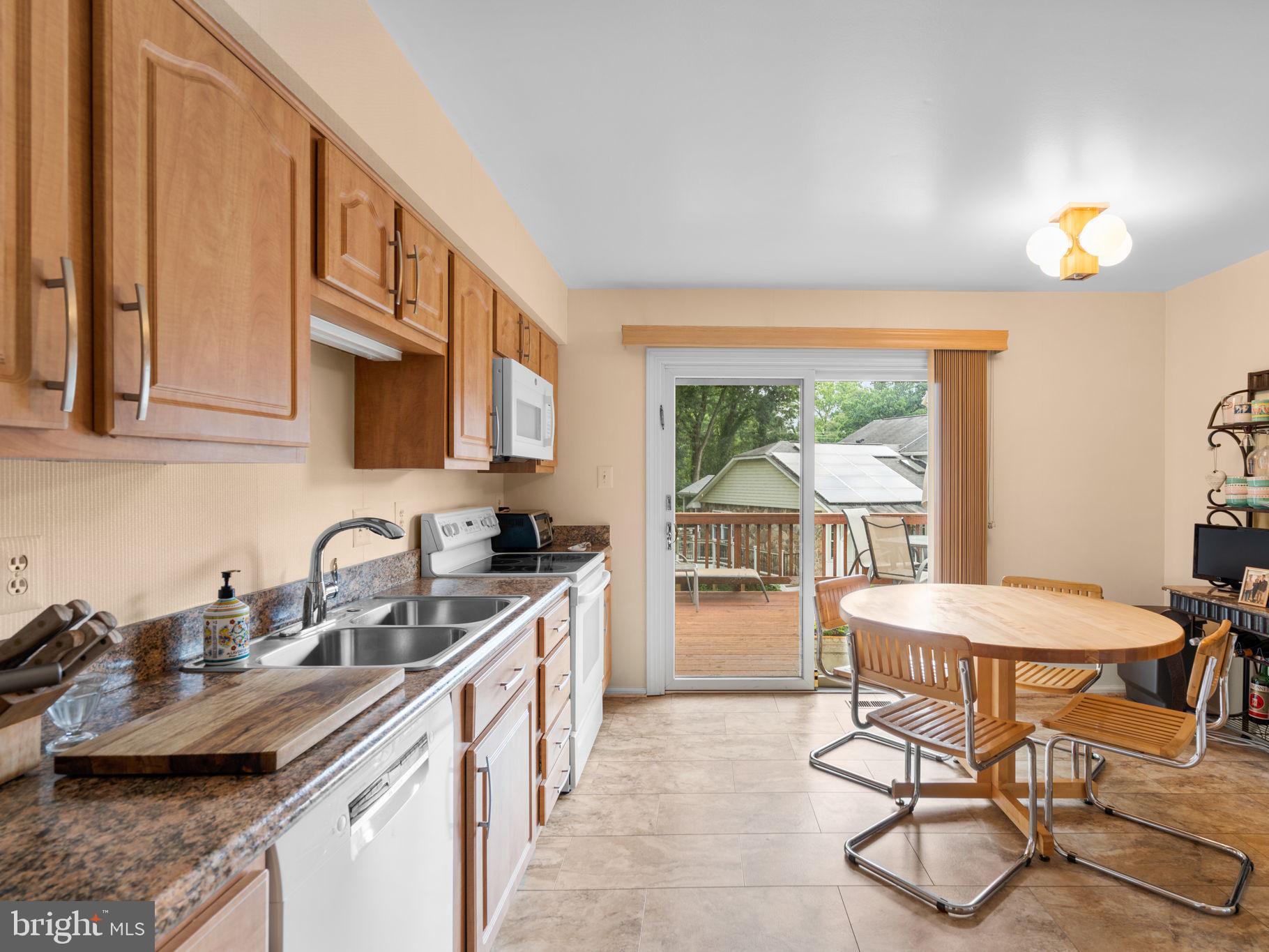 1709 Glastonberry Road Rockville, MD 20854 - Photo 4 of 27 a kitchen with stainless steel appliances granite countertop a sink a stove and a wooden cabinets