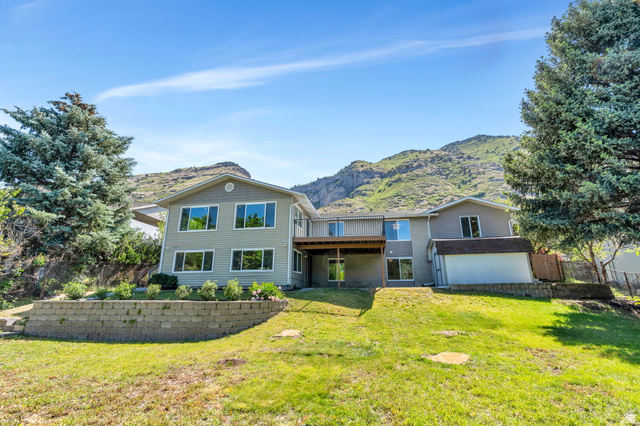 3813 North Foothill Drive Provo, UT 84604 - Photo 53 of 71 Multi-level residence featuring a rear elevated deck, ground-level patio, and a retaining wall with landscaping