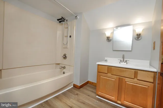 a bathroom with a tub sink and mirror