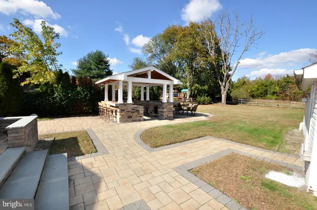 a view of a house with a yard patio and fire pit