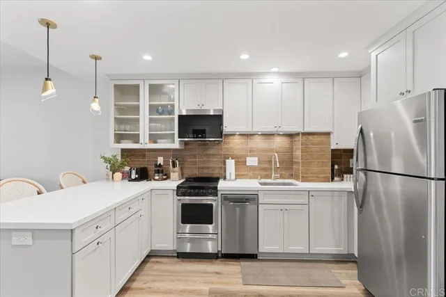a kitchen with a sink a stove a refrigerator and cabinets