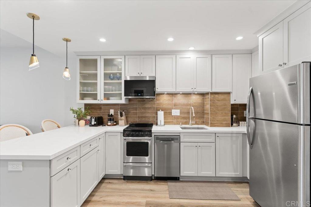 2003 Costa Del Mar Road, Unit 679 Carlsbad, CA 92009 - Photo 4 of 18 a kitchen with a sink a stove a refrigerator and cabinets
