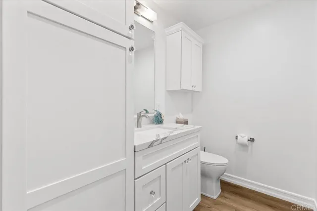a bathroom with a granite countertop white sink a toilet and a shower curtain