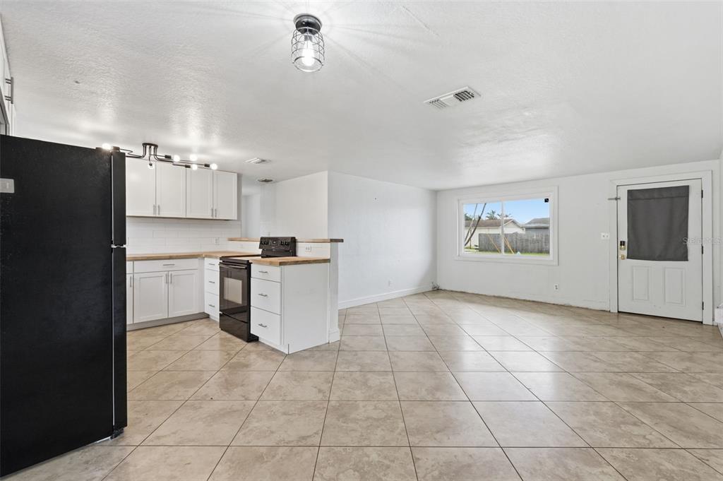 5421 64th Avenue North Pinellas Park, FL 33781 - Photo 5 of 43 a kitchen with granite countertop a refrigerator and a stove top oven