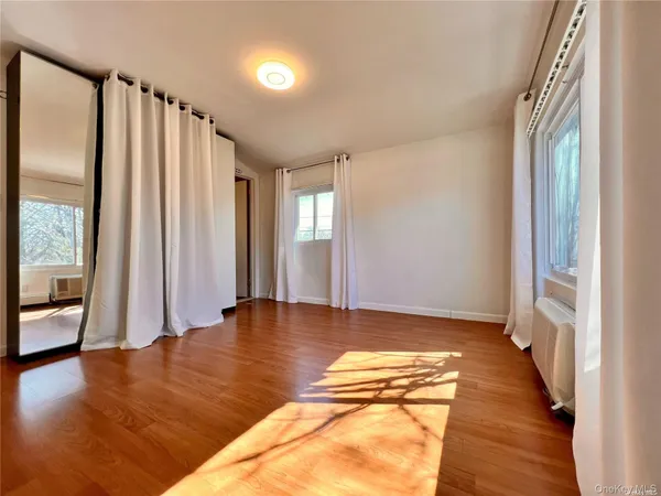 a view of room with window and wooden floor