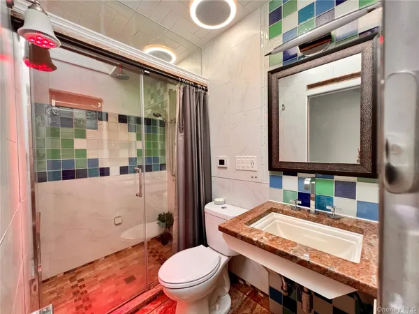 a bathroom with a granite countertop toilet sink and mirror