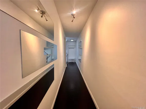 a view of a hallway with wooden floor and staircase
