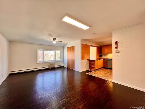 a view of empty room with wooden floor and windows