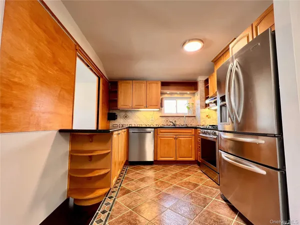 a kitchen with stainless steel appliances granite countertop a refrigerator sink and stove