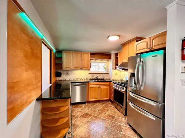 a kitchen with stainless steel appliances granite countertop a refrigerator and a stove top oven