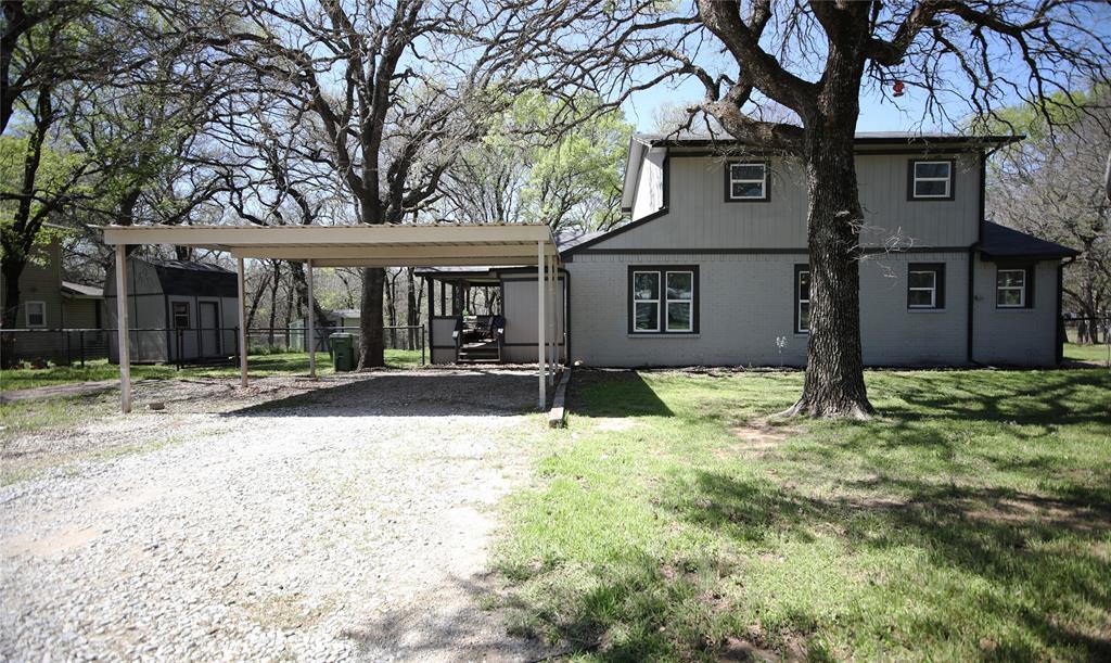 Traditional-style home featuring driveway, carport and a patio