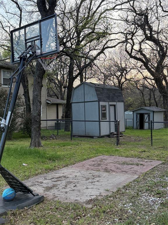 150 Ash Creek Court Springtown, TX 76082 - Photo 16 of 20 View of concrete area with basket ball goal and storage sheds