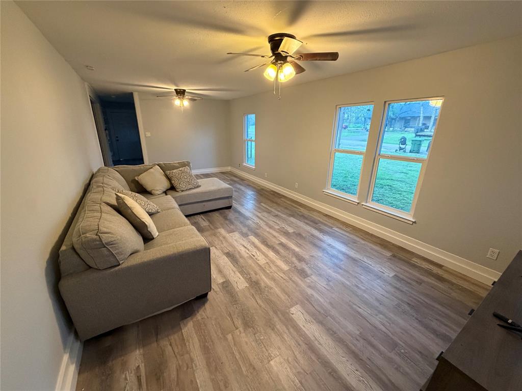 150 Ash Creek Court Springtown, TX 76082 - Photo 5 of 20 Living room with wood finished floors and ceiling fans