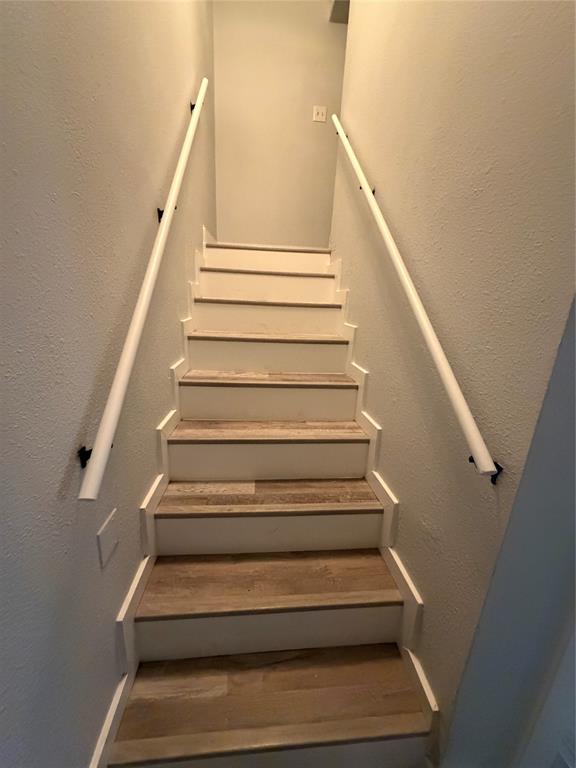 150 Ash Creek Court Springtown, TX 76082 - Photo 10 of 20 Stairs featuring a textured wall and wood finished floors