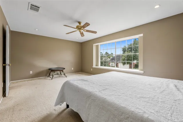 a spacious bedroom with a large bed and a chandelier