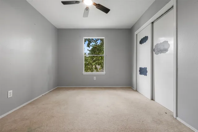 an empty room with windows and closet