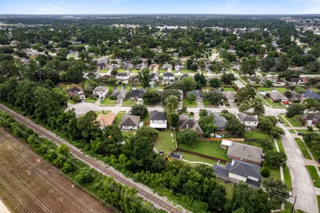 an aerial view of residential houses with outdoor space and trees