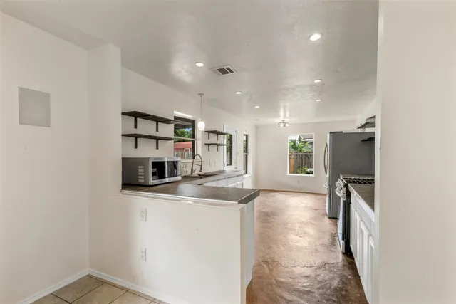 a view of a kitchen with a sink and refrigerator