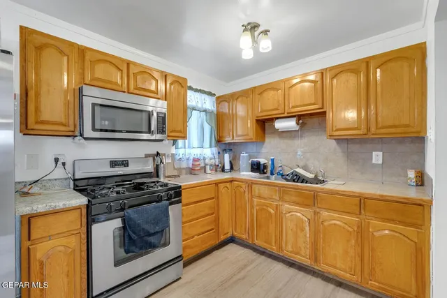 a kitchen with stainless steel appliances granite countertop wooden cabinets microwave and stove top oven