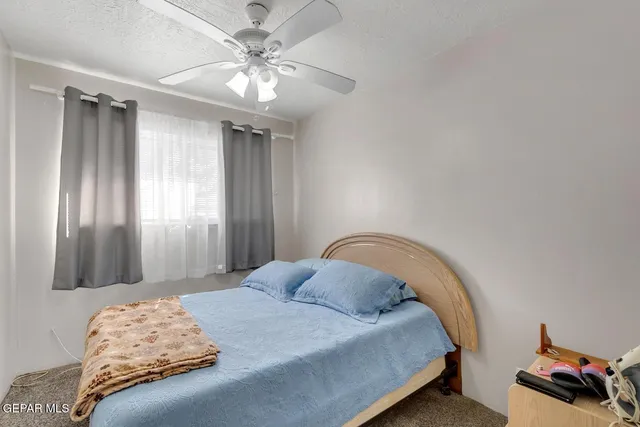 a bedroom with a bed and a chandelier fan