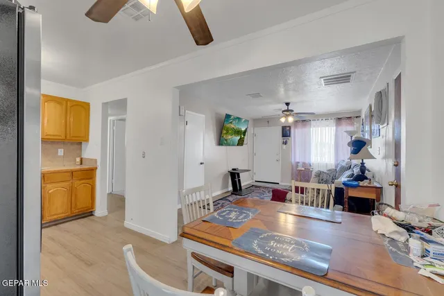 a living room with stainless steel appliances furniture a rug and a view of kitchen
