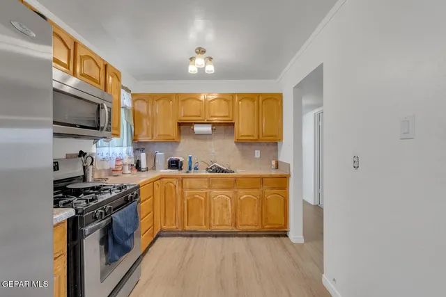 a kitchen with stainless steel appliances a sink cabinets and a stove top oven