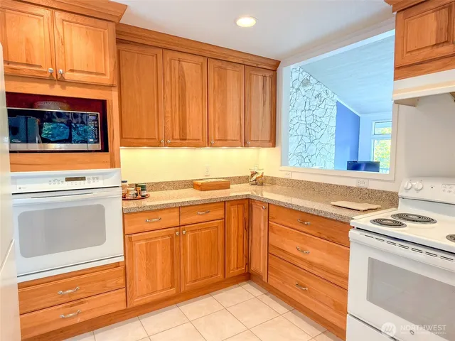a kitchen with granite countertop cabinets stainless steel appliances and a window