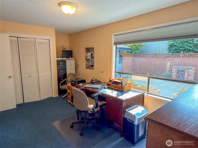 a view of a workspace with furniture and a window
