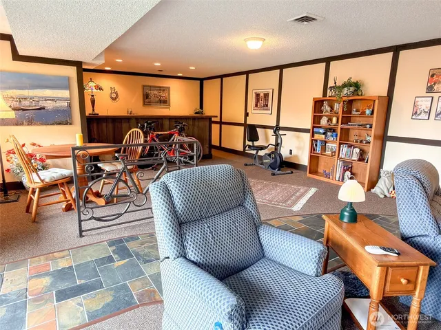 a living room with furniture a rug and a floor to ceiling window