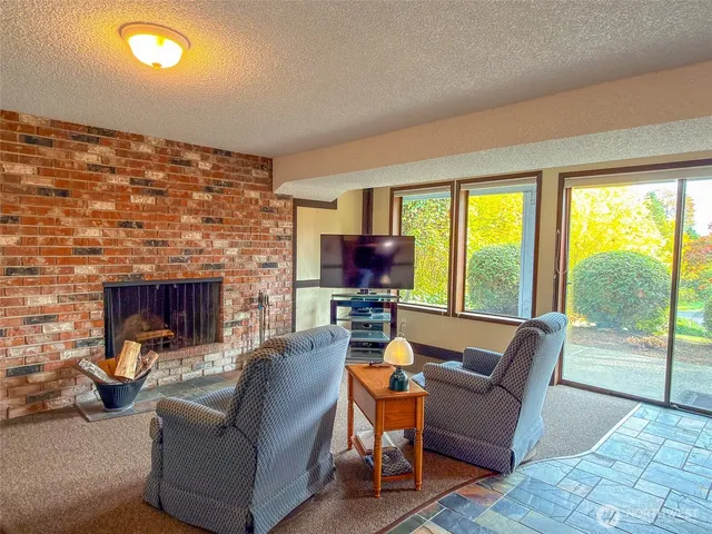 a living room with furniture a floor to ceiling window and a flat screen tv