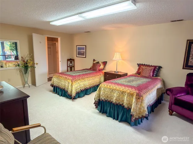 a spacious bedroom with two beds and dresser