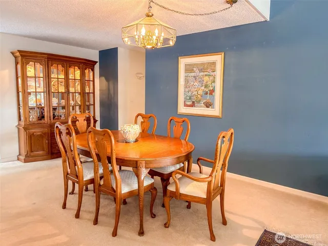 a dining room with furniture a chandelier and window