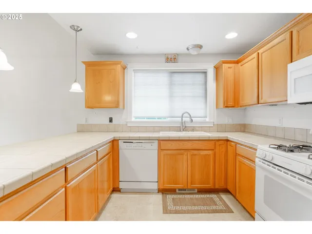 a kitchen with kitchen island a sink stainless steel appliances and cabinets