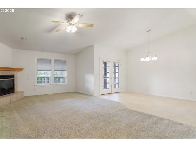 a view of an empty room with a fireplace and a window