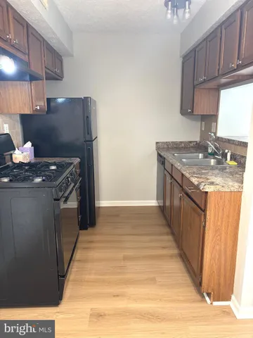 a kitchen with stainless steel appliances granite countertop a stove a sink dishwasher and a refrigerator