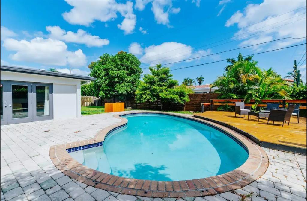 2521 Northeast 51st Street Lighthouse Point, FL 33064 - Photo 22 of 24 a view of a swimming pool with a lounge chairs in the patio