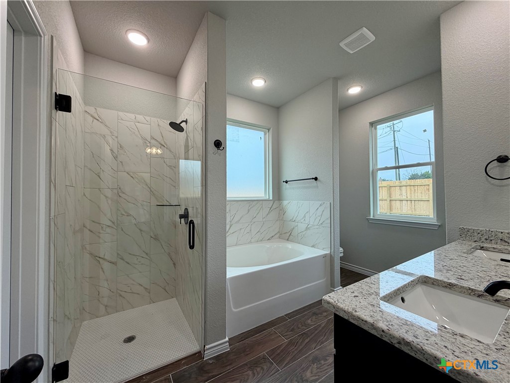 6903 Wizard Drive Killeen, TX 76549 - Photo 12 of 23 a bathroom with a granite countertop sink a toilet and shower