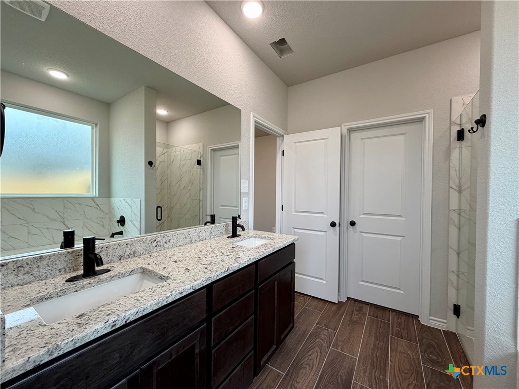 6903 Wizard Drive Killeen, TX 76549 - Photo 14 of 23 a bathroom with a granite countertop double vanity sink and mirror