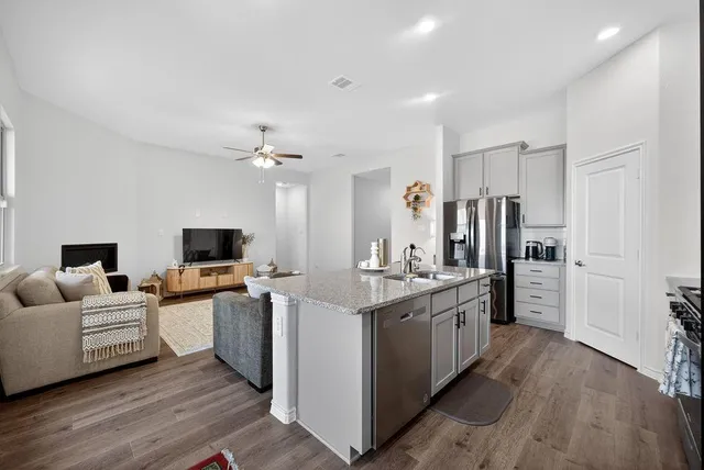 a kitchen with stainless steel appliances a stove top oven and refrigerator