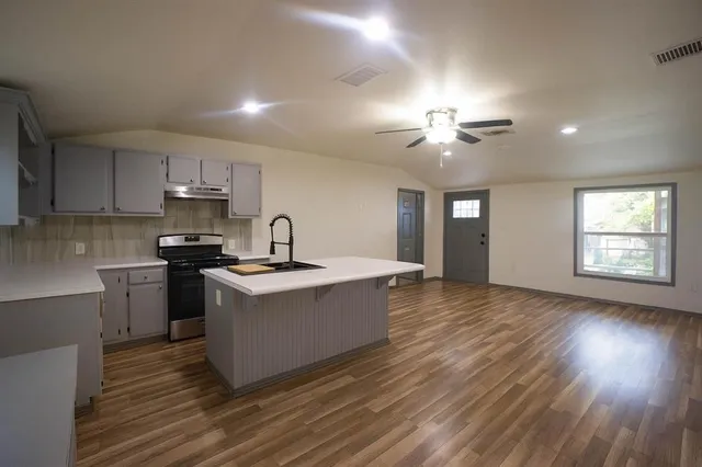a kitchen with a sink and wooden floor