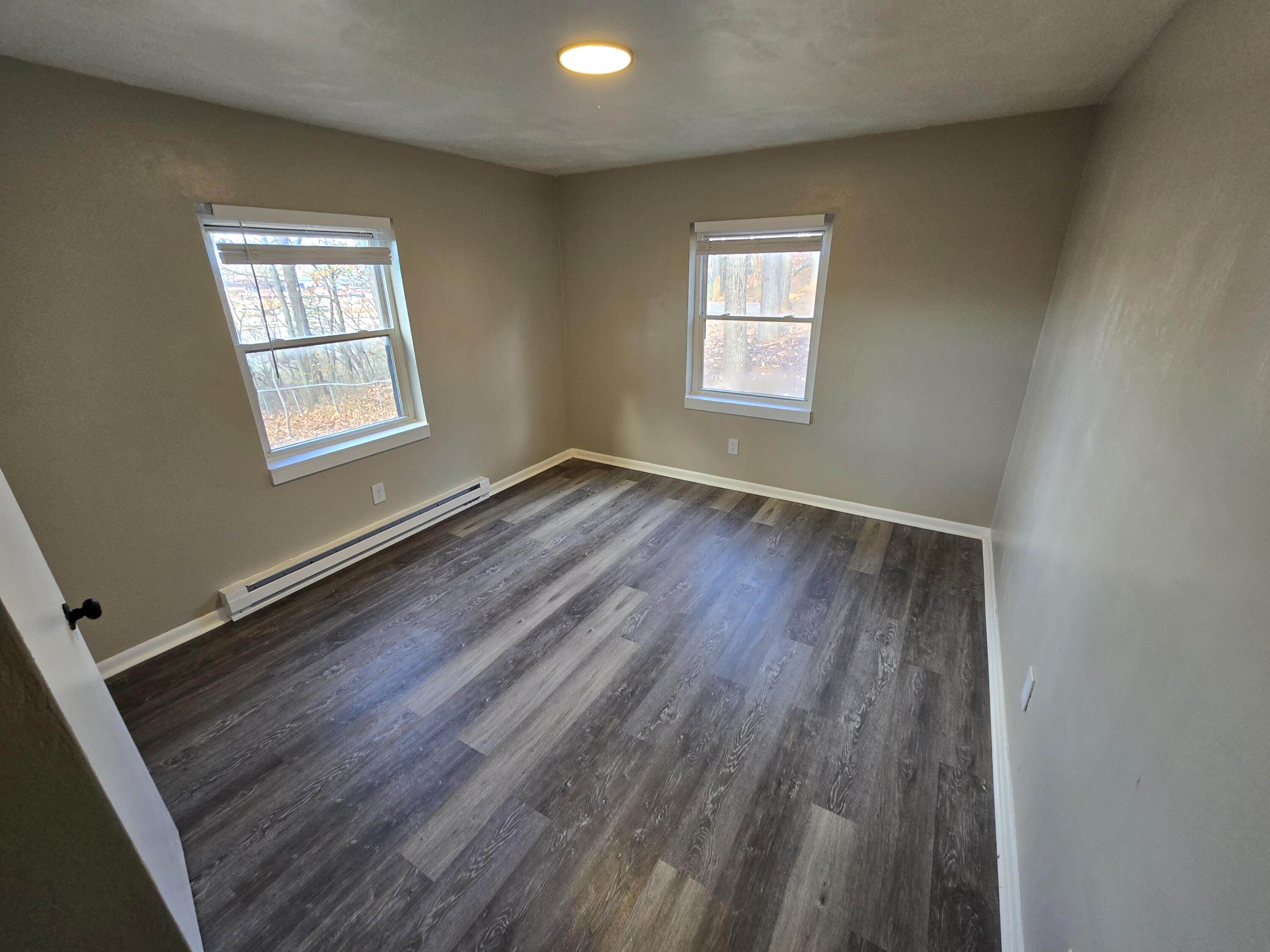 2646 Westover Avenue Southwest, Unit 8 Roanoke, VA 24015 - Photo 2 of 6 a view of an empty room with wooden floor and a window