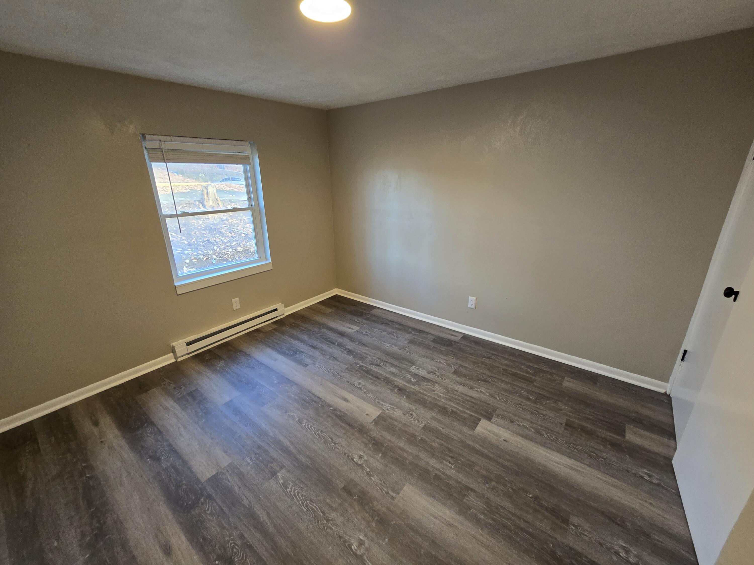2646 Westover Avenue Southwest, Unit 8 Roanoke, VA 24015 - Photo 4 of 6 an empty room with wooden floor and windows