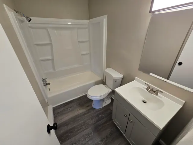 a bathroom with a sink a toilet and a mirror