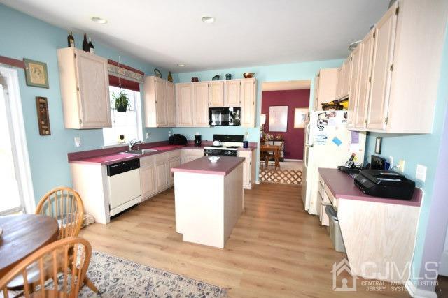 42 Timber Ridge Road North Brunswick, NJ 08902 - Photo 36 of 43 a kitchen with stainless steel appliances kitchen island granite countertop a stove a sink dishwasher and white cabinets with wooden floor